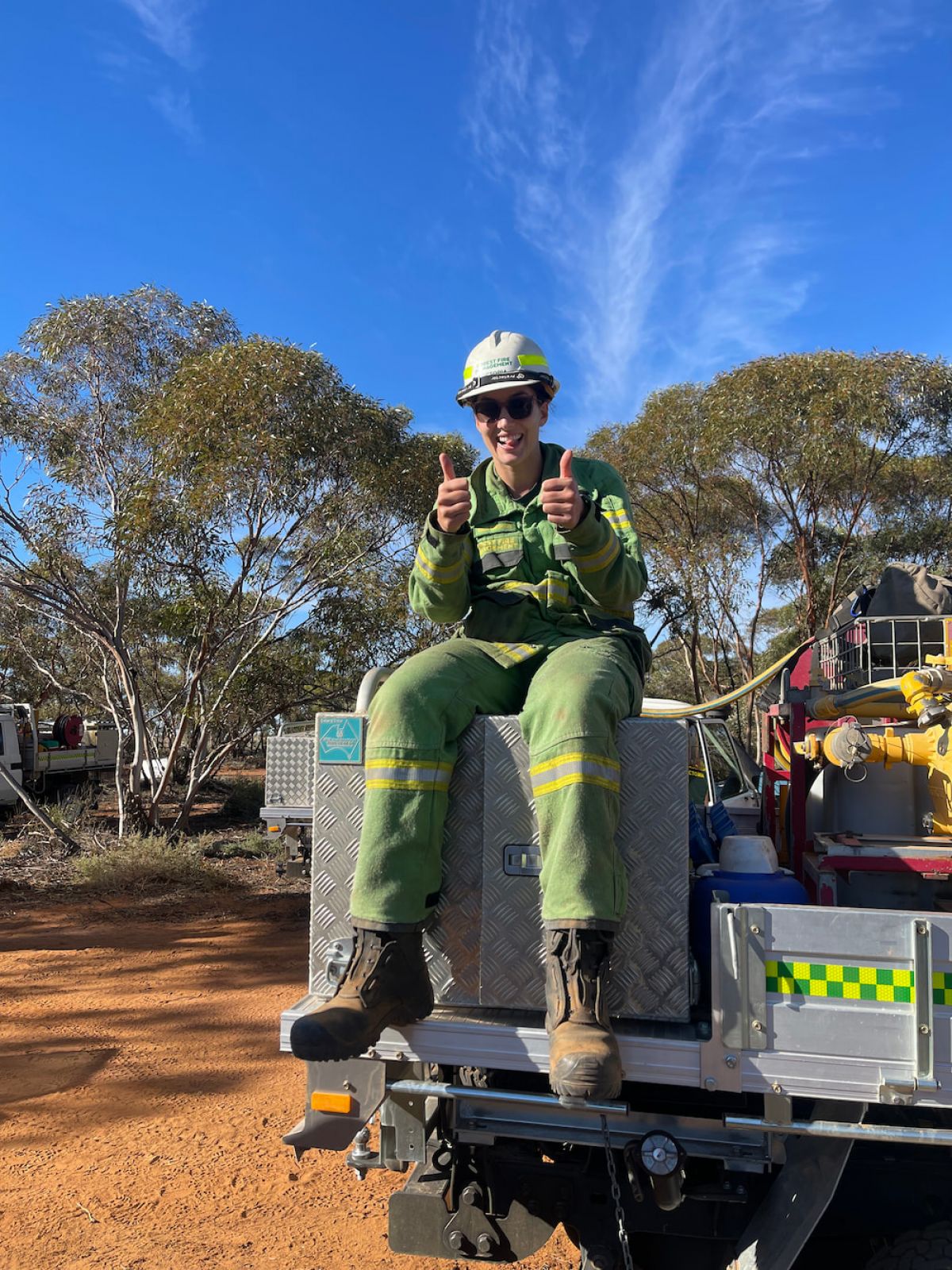 Kiana sitting on back of ute giving a thumbs up sign