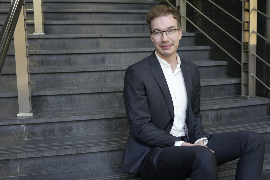 Photo of Jordan sat outside on steps of government building