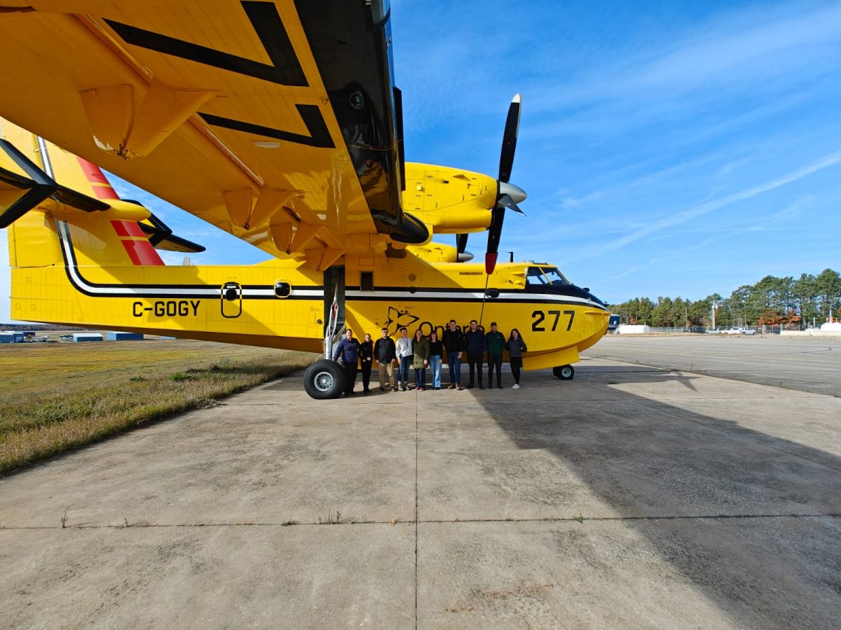 Study tour group photo with plane