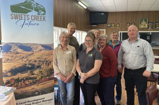 People in front of Swifts Creek banner